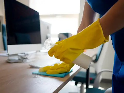 Professional wiping down an office desk