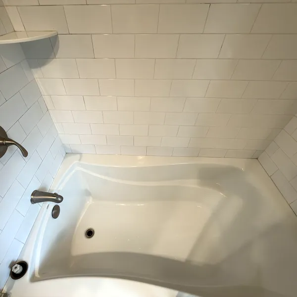 Bright white bathtub and tile after deep cleaning services