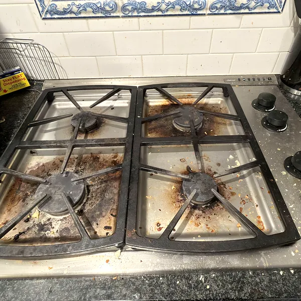 Greasy gas stovetop before a deep house cleaning